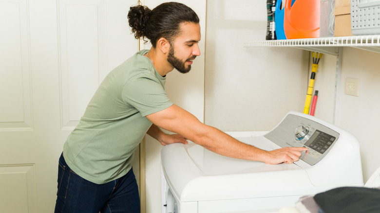 Man pressing button on dryer console
