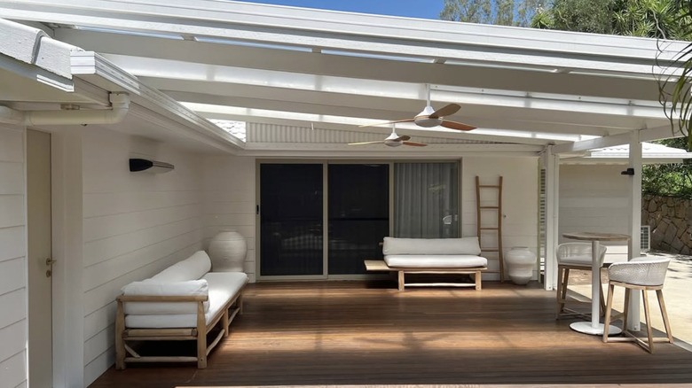 A home with white cladding installed over a brick wall