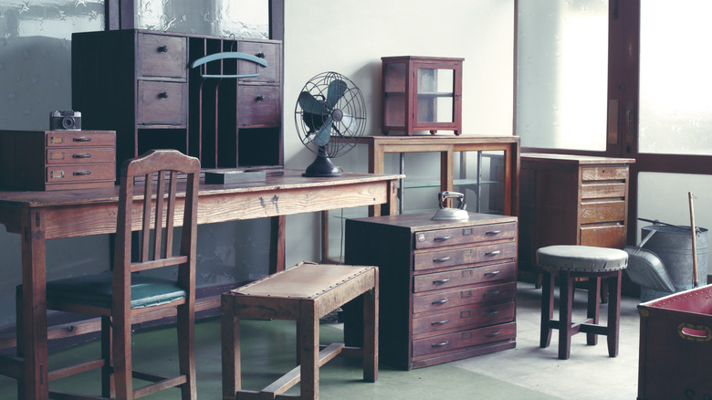 A selection of antique furniture pieces in a corner, including a desk