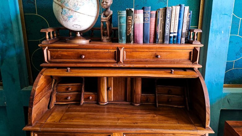A refurbished antique desk with books and a globe on it
