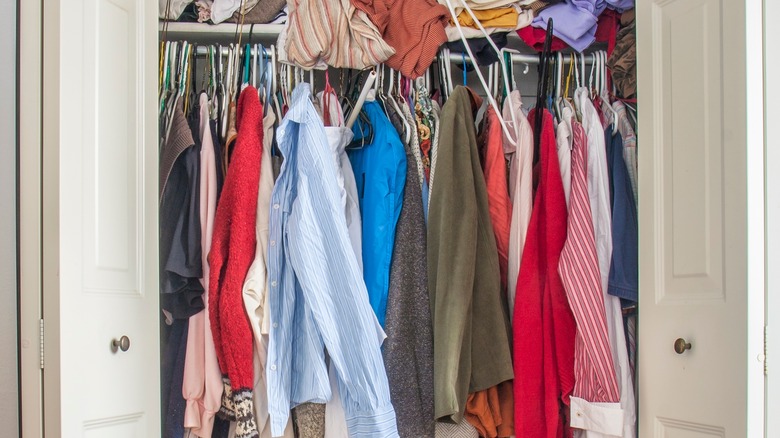 A small closet crammed with clothing