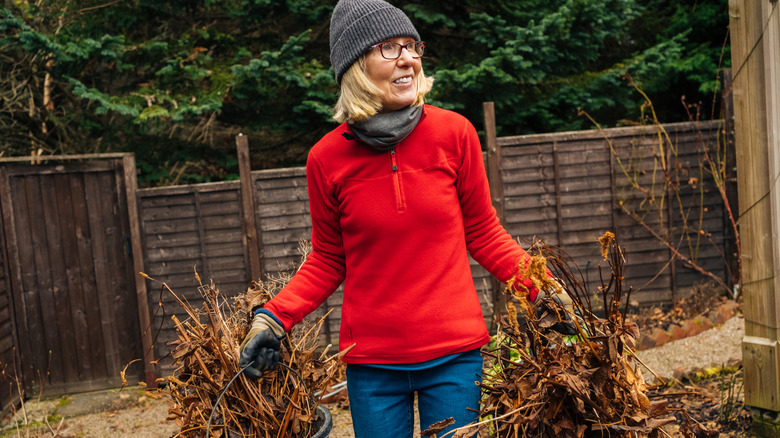 A woman cleaning up her garden in winter