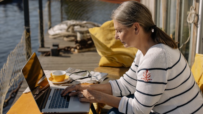 woman typing on laptop outdoors