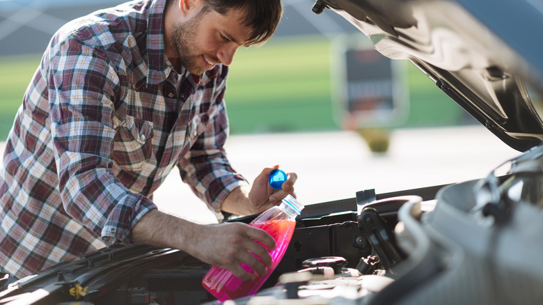 A man adding anti-freeze to his car