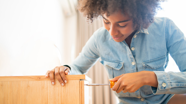 person putting together cabinet