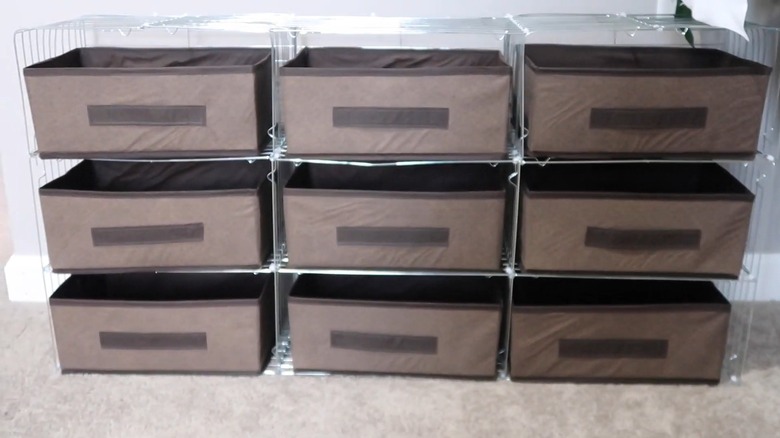 A DIY storage system made from zip tied cooling racks holds nine brown fabric baskets.