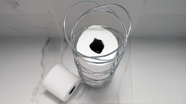 Toilet paper in a freestanding wire toilet paper holder
