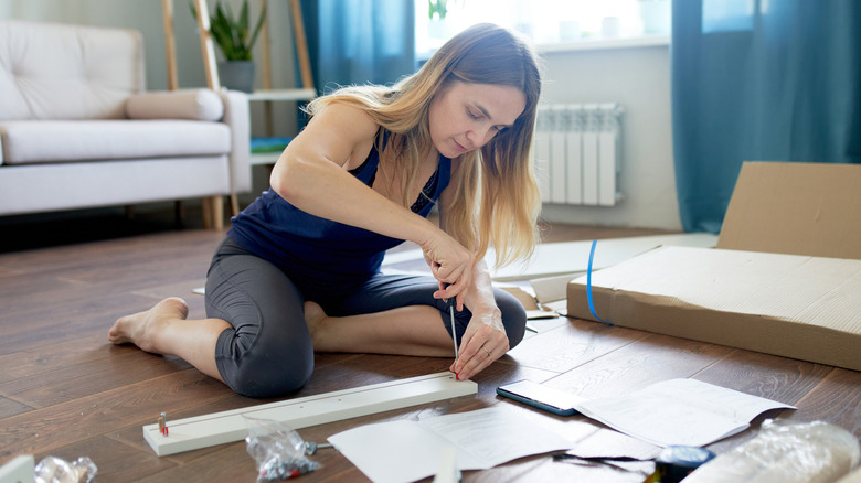 woman assembling an ikea cabinet