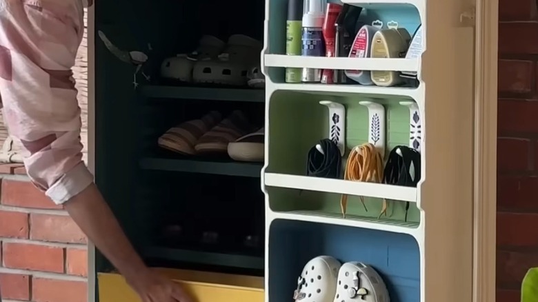 A colorful fridge interior storing shoes, shoelaces, sprays, and more.