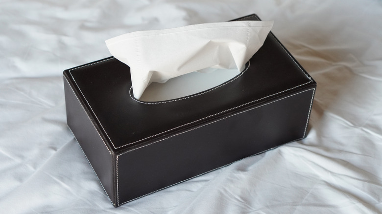 Faux leather covered tissue box holder on bed