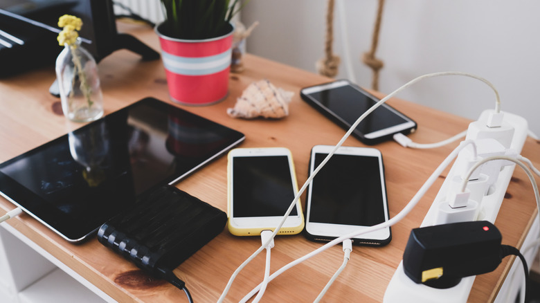 A tabletop filled with charging electronic devices
