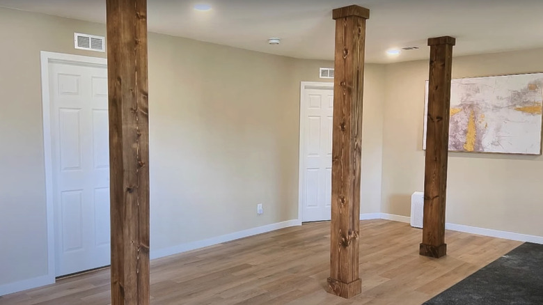 A basement with three wood columns.