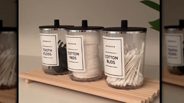 Bathroom storage jars on a wooden tray