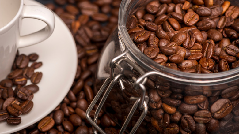 Coffee cup with coffee beans in a Mason jar