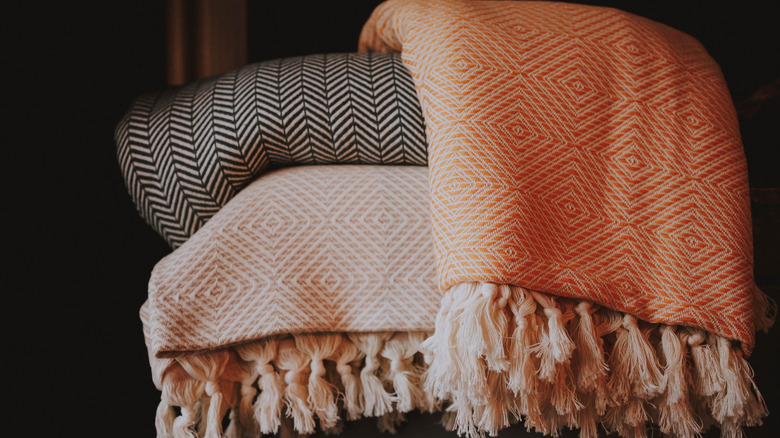 A pile of throw blankets sits on the floor.