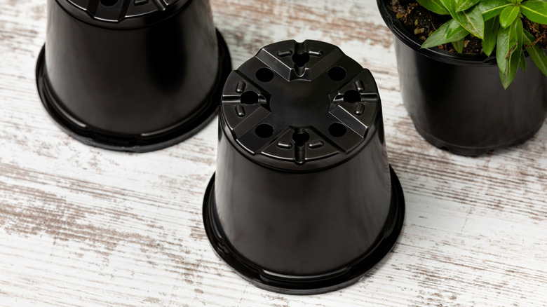 upside down black nursery pots on table