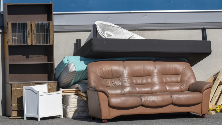 A pile of old furniture being stored outdoors