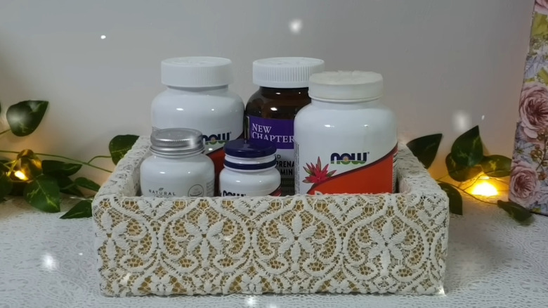 an organizer storage box covered with metallic paint and old lace curtain scraps