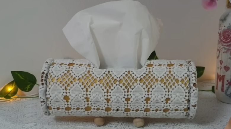 a round tissue box made from old lace curtains and a hard cardboard roll