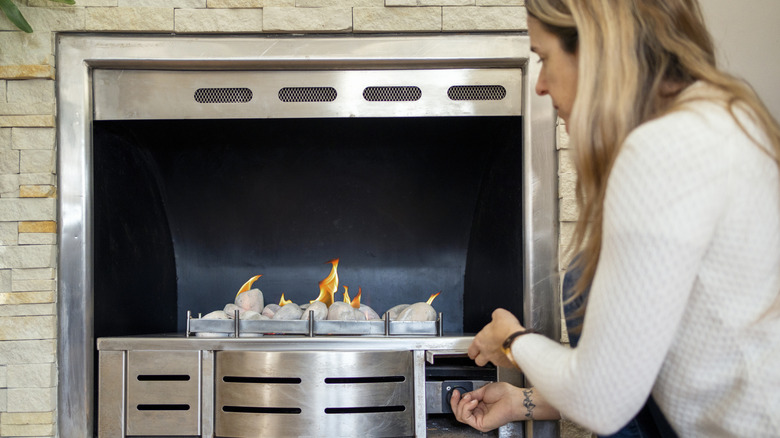 Woman turning on a gas fireplace
