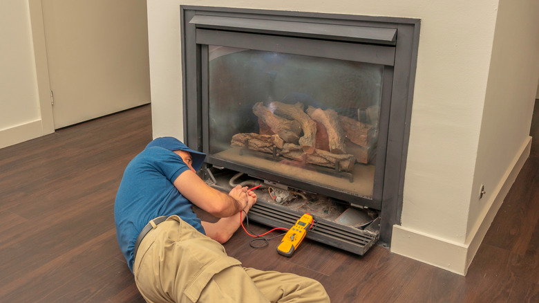 Man working on a gas fireplace insert