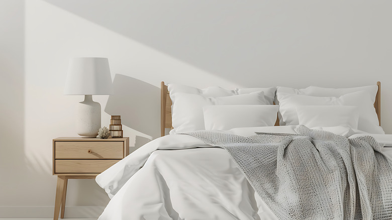 Minimalist white bedding with neutral knit blanket