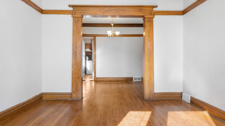 Doorway of empty room in home featuring outdated traditional wooden trim
