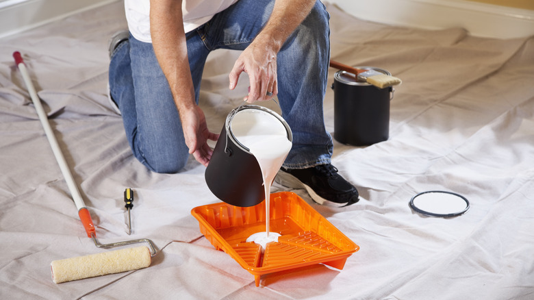 Man pouring paint in tray