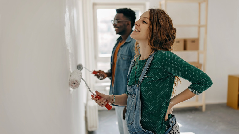 Couple painting a wall