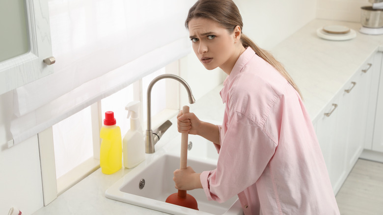 Woman plunging sink