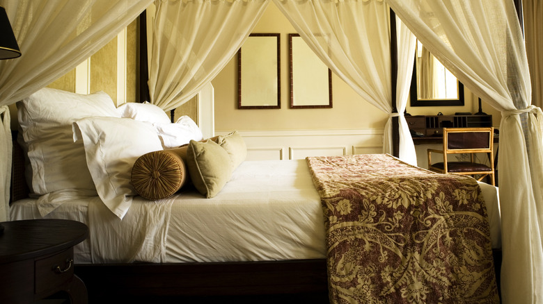 Bedroom with canopy bed in front of open French doors