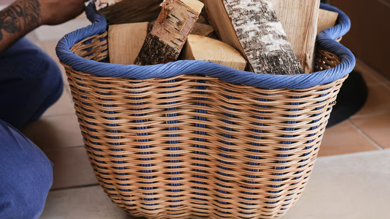 OMMJÄNGE basket holding large pieces of wood for a fire