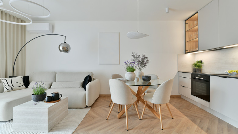 Photo of Modern Open-Plan Living Room with Japandi Style, White Sofa, Led Ring Chandelier, Herringbone Wood Flooring and Minimalist Fitted Kitchen