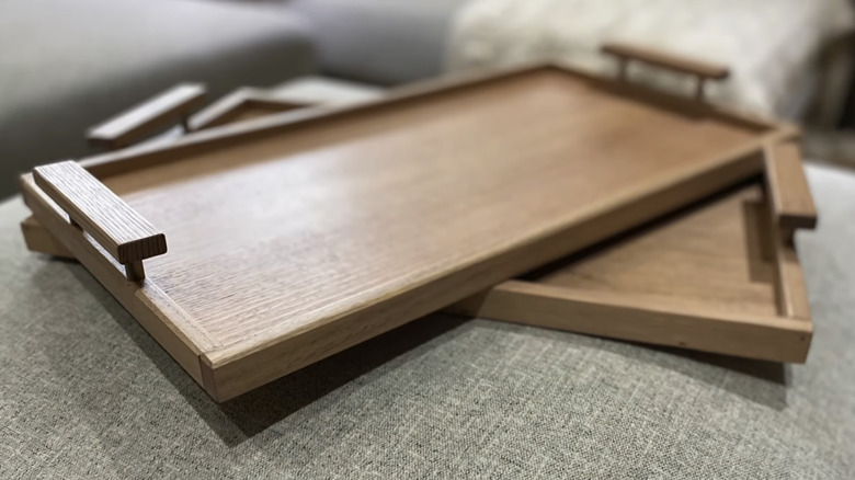 Two wooden trays placed atop a couch.