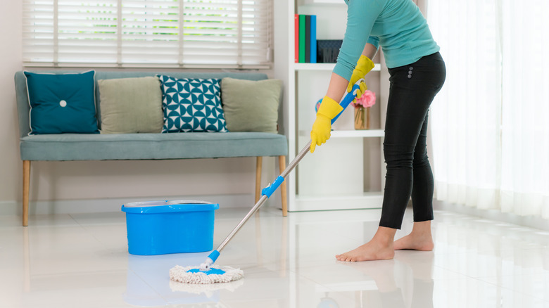 woman mopping tile floor barefoot