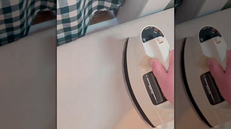 Ironing a drop cloth on a table