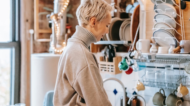 woman in small cluttered kitchen