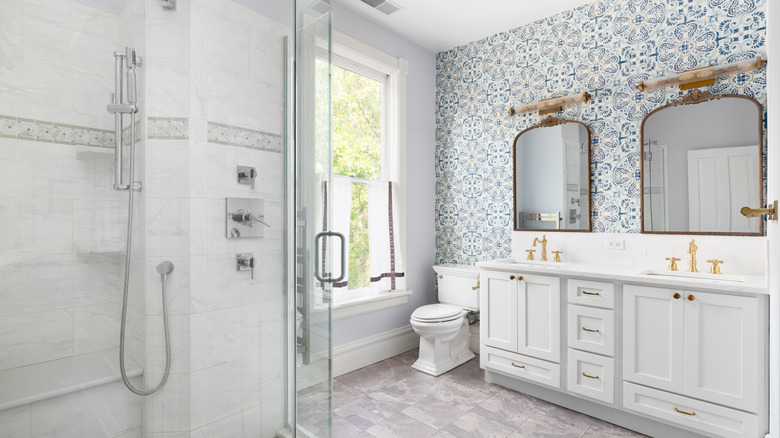 Blue ornate wallpaper in minimalist white bathroom with modern fixtures