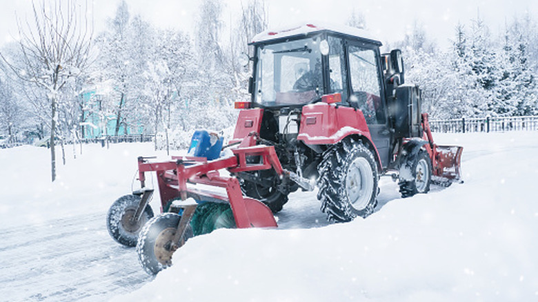 Small red tractor removing snow