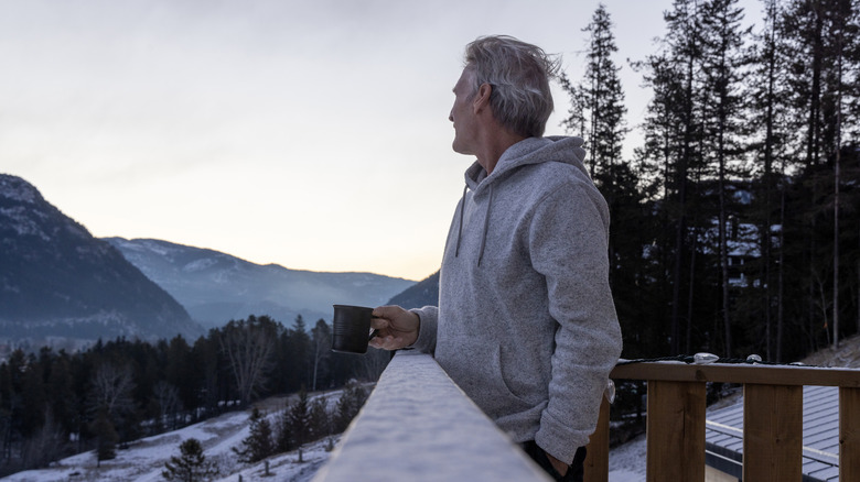 man standing on rooftop winter
