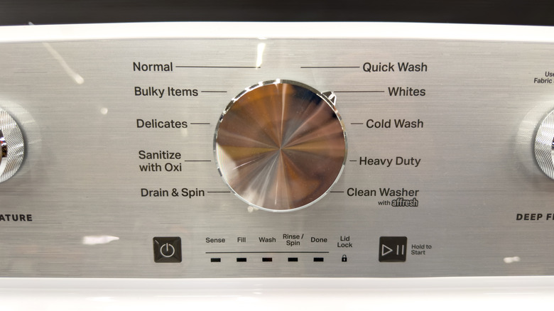 A washing machine control panel with the sanitize feature listed among the settings.