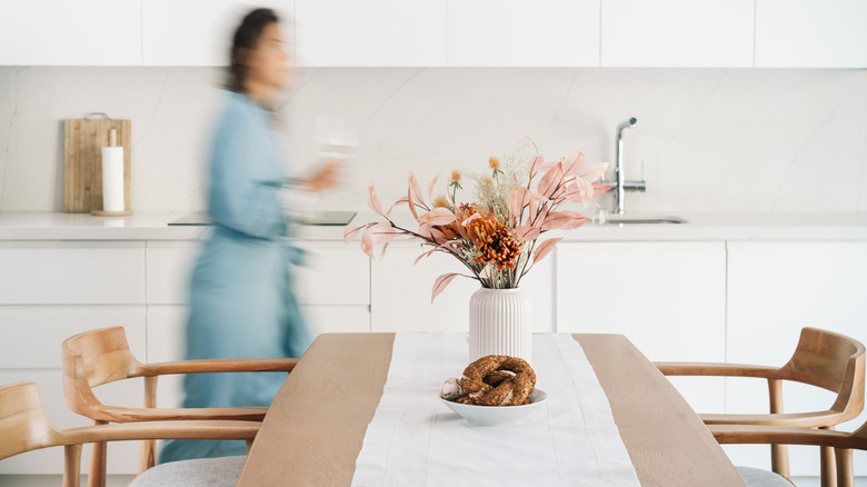 Blurred woman in minimalist design kitchen