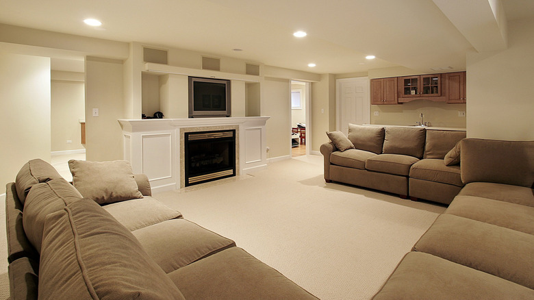 A basement with couches and a TV.