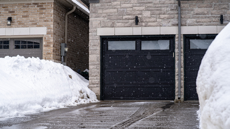 Residential garages with driveways surrounded by winter snow