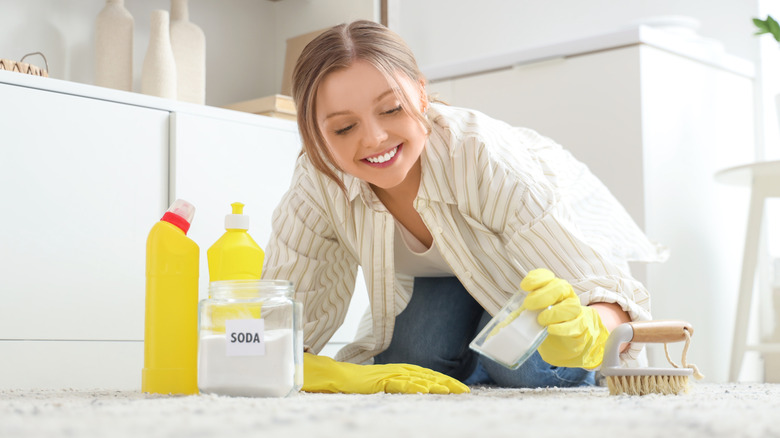Woman scrubbing a white rug in a bright room