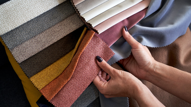hands holding upholstery fabric samples