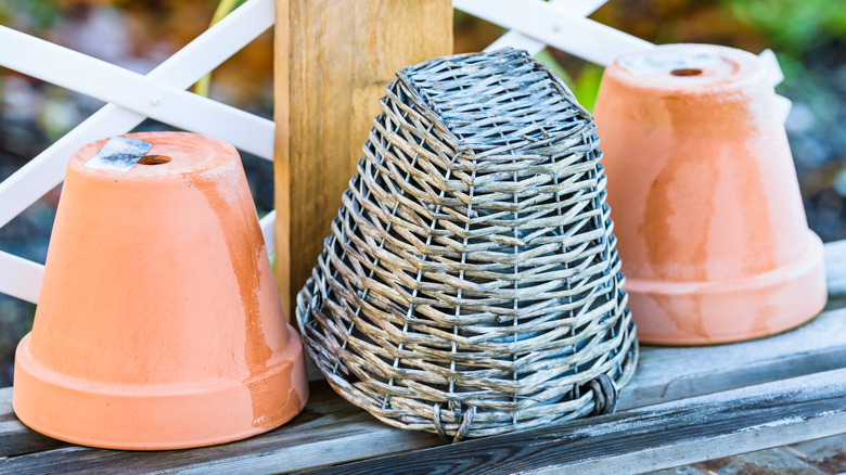 Upside down flowerpots or planters with basket.
