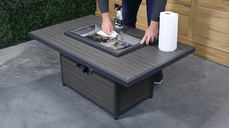 Man cleaning a gas fire pit