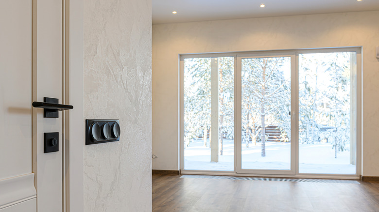 Interior of a home with a large sliding glass door looking out on a winter scene