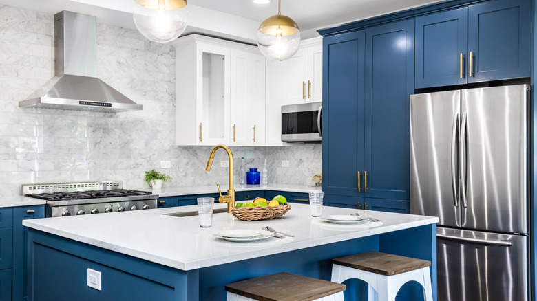 A two-toned kitchen with blue cabinets on the bottom and sides and white cabinets on top